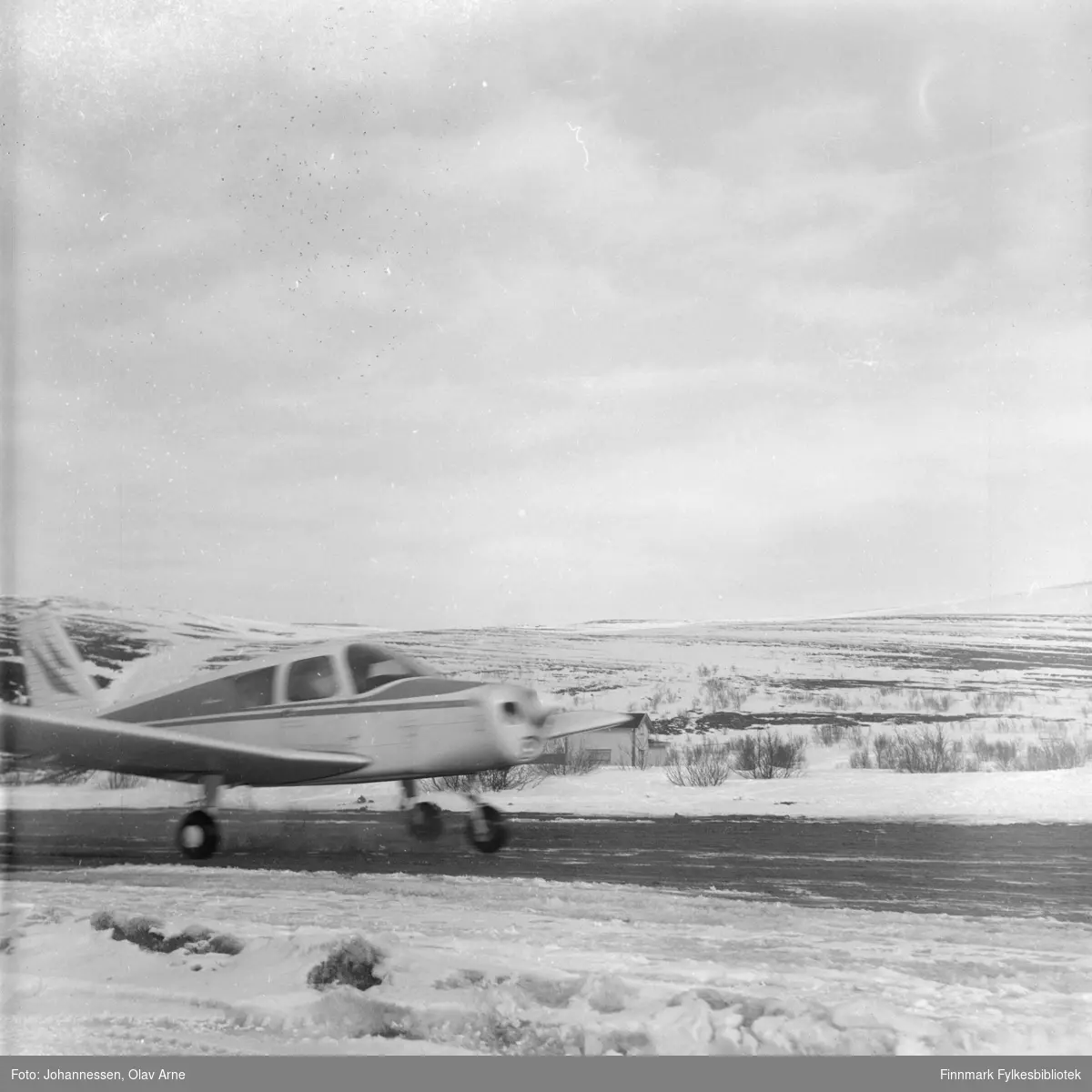 Foto av propellfly på Båtsfjord Flyplass på tidlig 1970-tallet

Flyet er omringet av sne og man ser vinterlandskap i bakgrunnen 