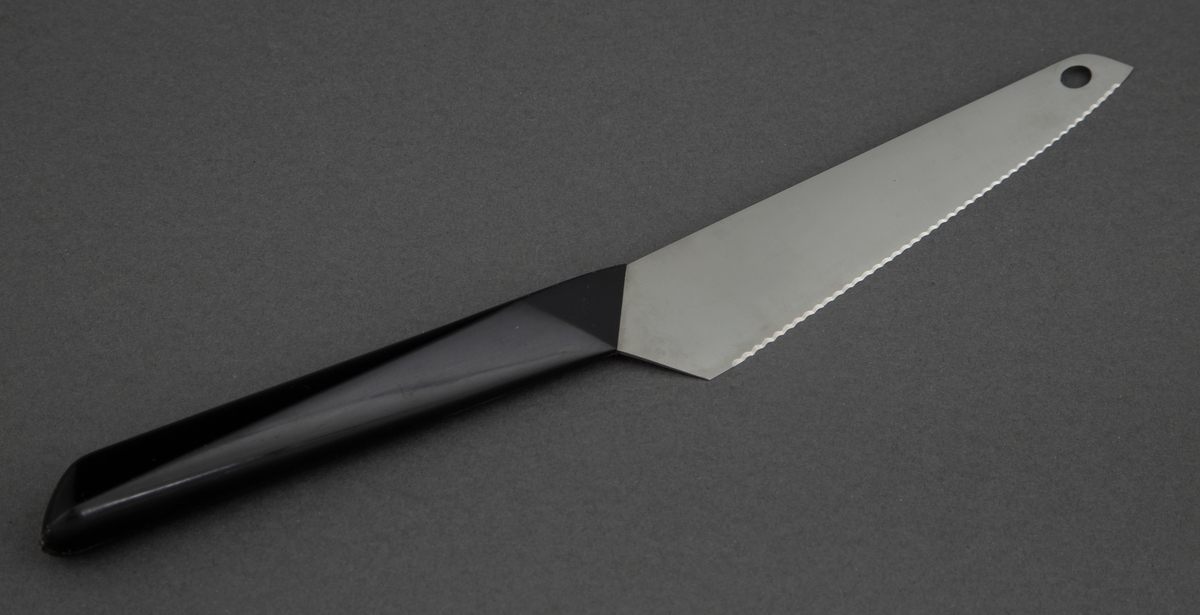 Brødkniv i rustfritt stål med svart, kantete nylonskaft. Skaftet er festet skrått til bladet. Utstanset oval øverst i knivbladet for oppheng.