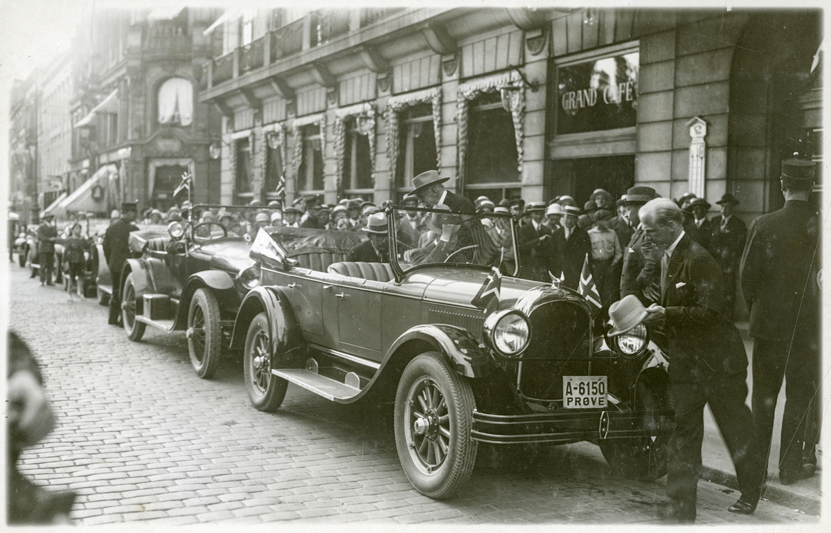 Roald Amundsen stiger opp i åpen bil i bilkortesje i Karl Johans gate v/Grand Hotel, omgitt av mange tilskuere - Roald Amundsens ankomst til Oslo med S/S "Bergensfjord" efter "Norge"s færden over Polen - 16. juli 1926.