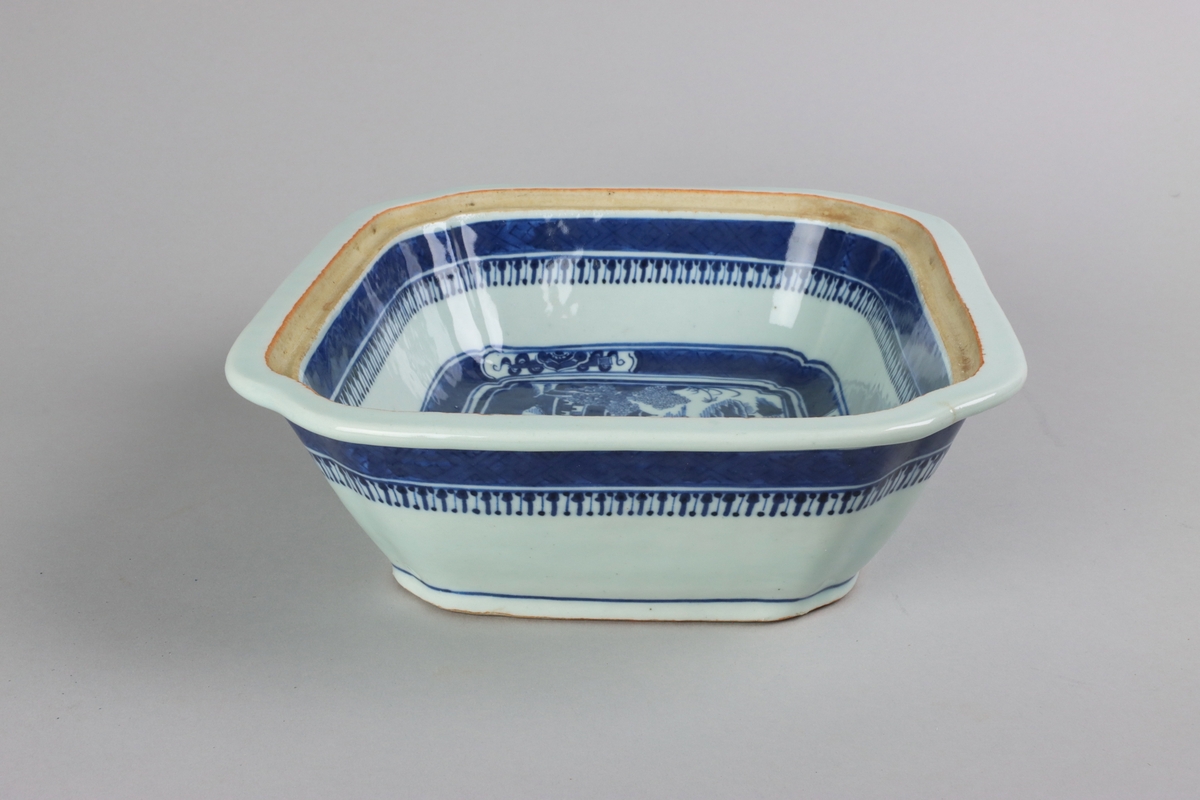 Square form with chamfered corners, a flat plain rim. The inside of the dish slightly everted and below the rim a wide dark blue bord with a criss cross pattern. A bord with criss cross pattern and reserves with symbols of good fortune surrounds the well. Centered in the well landscapes scenes with pagodas, buildings, waters, bridges and gardens. The the sides of the dish is below the rim decorated with a criss cross patterned bord. All decor in blue underglaze. The base is not decorated.