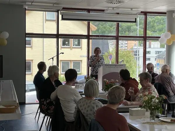 Kvinne holder tale i kafeen til Gjenreisningsmuseet.