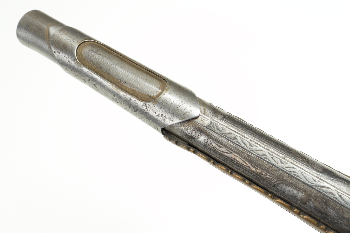Enpipig flintlåspistol med ornamenterad pipa av stål. Helkolv av mässing, ornamenterad. Näsband och varbygel, samt lås i stål. I pipan finns tre märken liknande "1.0". Mynningen är något trattformad. Pipan är slätborrad.
Inskrivet i huvudkatalogen 1974.