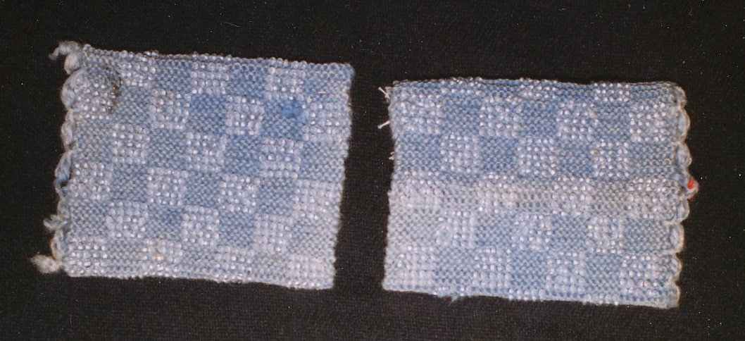Ett par armmuddar rätstickade av ljusblått ullgarn med instickade transparenta glaspärlor i maska 1-5, 11-15 osv. i ett schackrutigt mönster, virkad kant i uddar vid handleden.
 
Birgitta Blixt 2021.