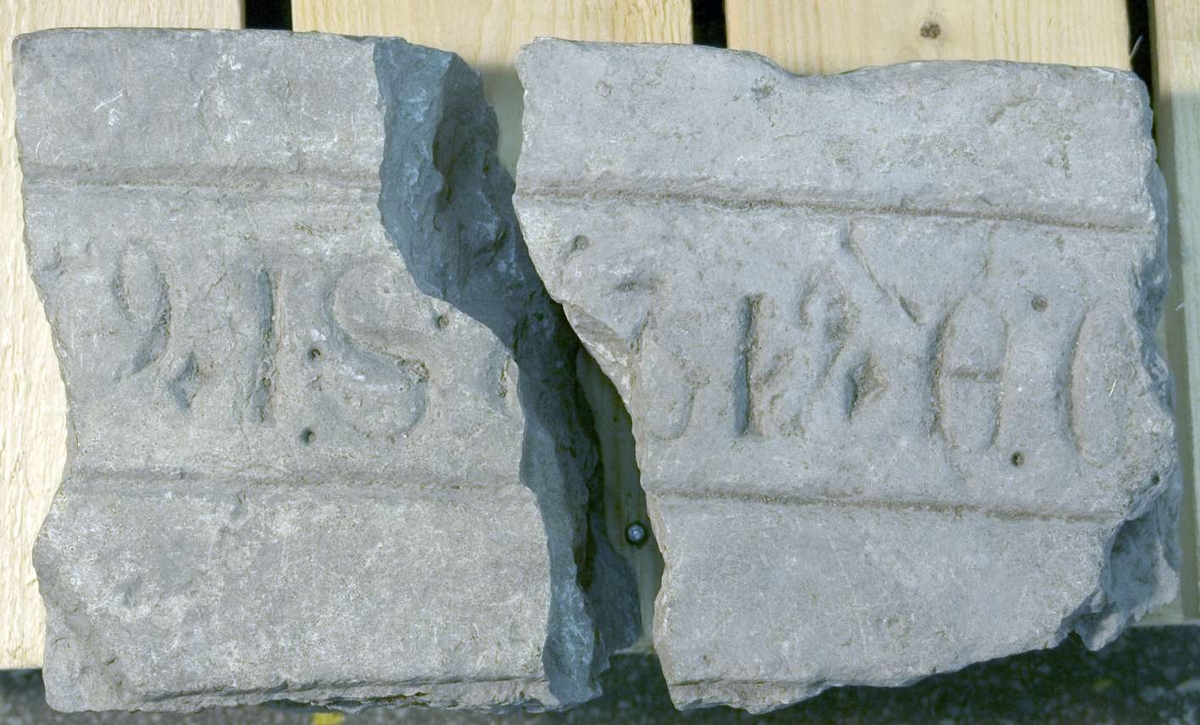 Fragment av gravhäll av kalksten, kluven i två delar. Kantskrift. Latinska bokstäver.
