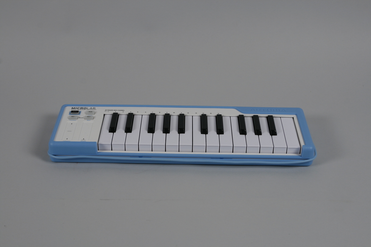 Lite digitalt keyboard med 25 taster. På venstre side for tastaturet to striper for justering samt fire knapper. USB-kabel som kan vikles rundt og festes i kanten av instrumentet. 