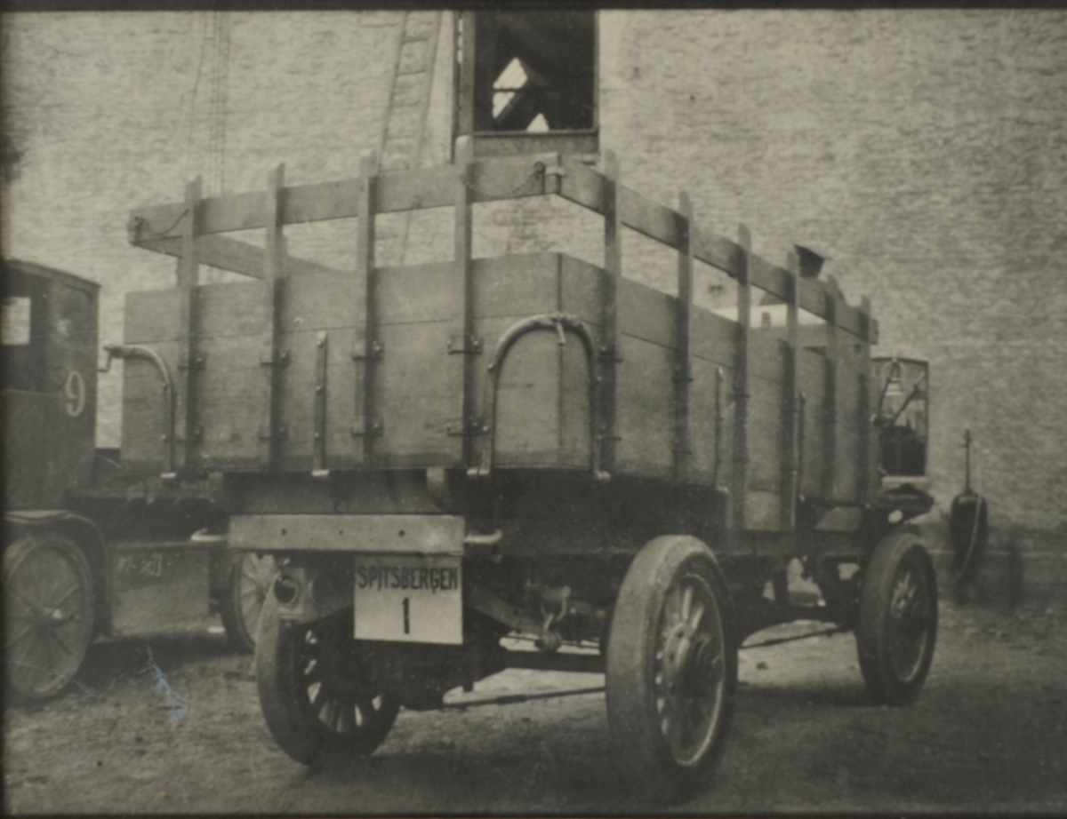 Bil med sjåfør, FWD(Four Wheel Drive) levert til Svalbard trolig sommeren 1920. Visstnok den første bilen her oppe. Sjåfør som overvintret fulgte med.Bilen hadde reg.nr. SPITSBERGEN 1. Innrammet bilde med påskrift om bilen på baksiden. SVB 1171
