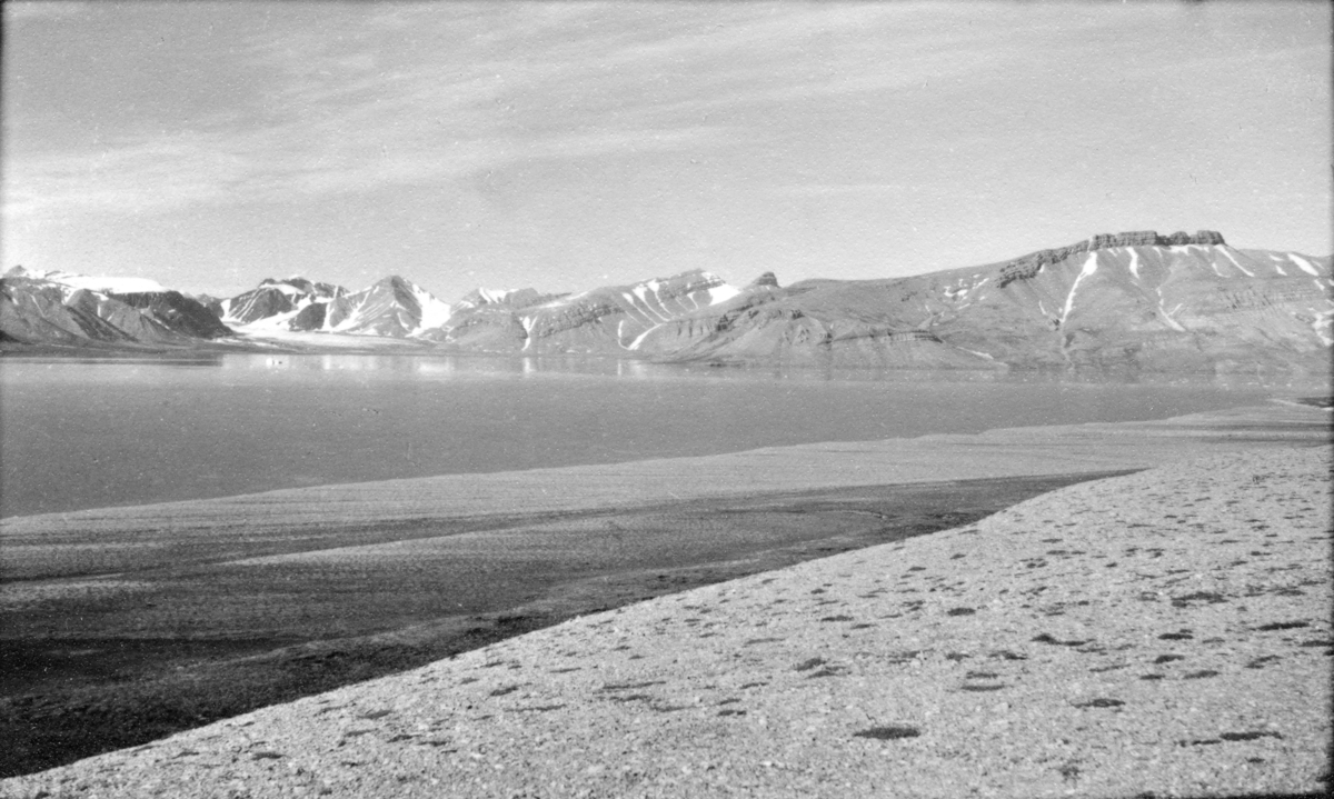 Petuniabukta og Wordiekammen. Bildet kommer fra The Cambridge Spitsbergen Expedition. Ekspedisjonen besto av seks menn, de fleste var geomorfologer, som dro fra England til Svalbard via Nordkapp og Bjørnøya om bord på Lyngen sommeren 1938. Målet deres var å kartlegge området rundt Nordenskioldbreen, Gipsvika og Brucebyen.