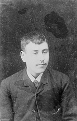 Portrett av en ukjent ung mann, kledd i mørk trøye, hvit skj