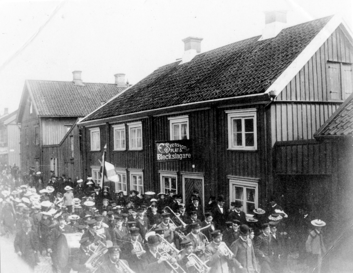 Musikkåren passerar Drottninggatan vid en 1:a maj demonstration. Till höger syns kvarteret Friden.