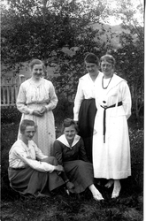 Fem kvinner samlet ute i en hage. Elever på husmorskole.