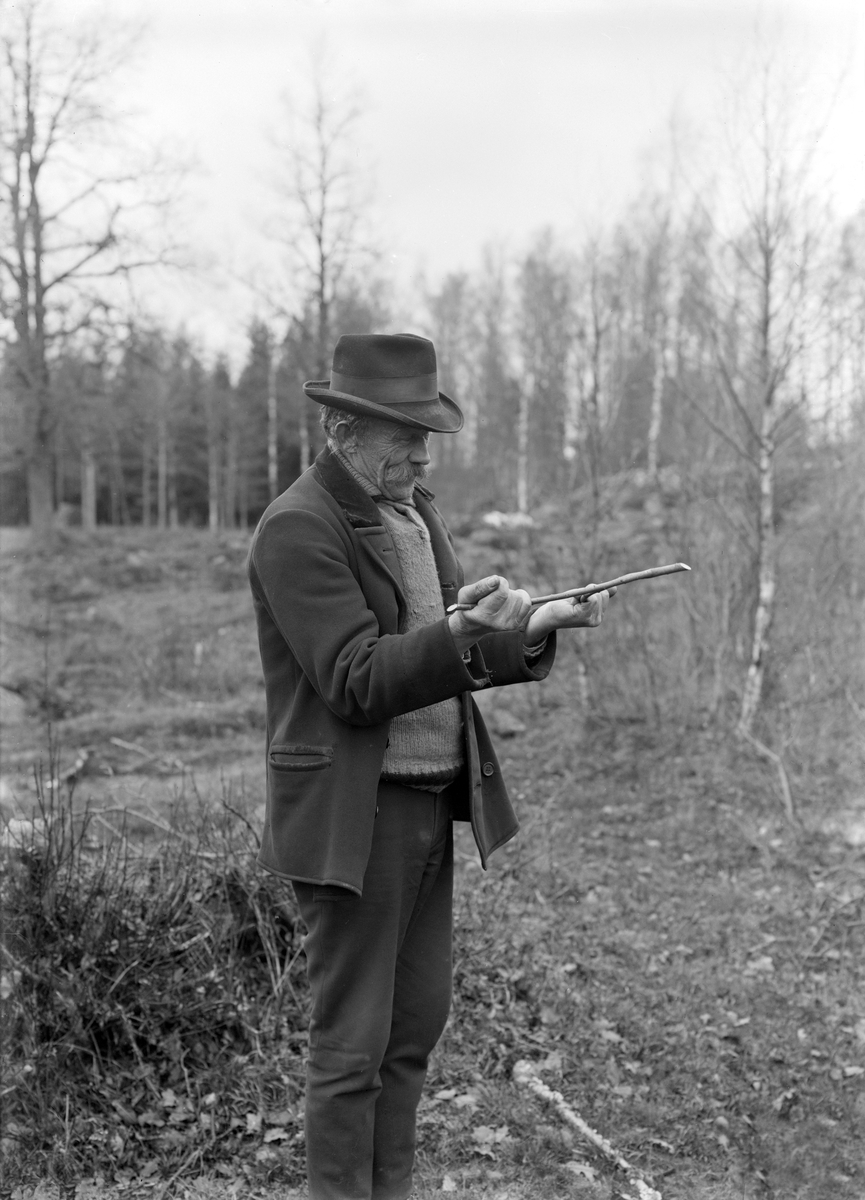 Innan det i fordom tid skulle grävas en brunn i Svinhultstrakten, anlitades gärna Herman Karlsson i Kärrstugan. Här ses han i full aktion med sin slagruta. Året är 1926.