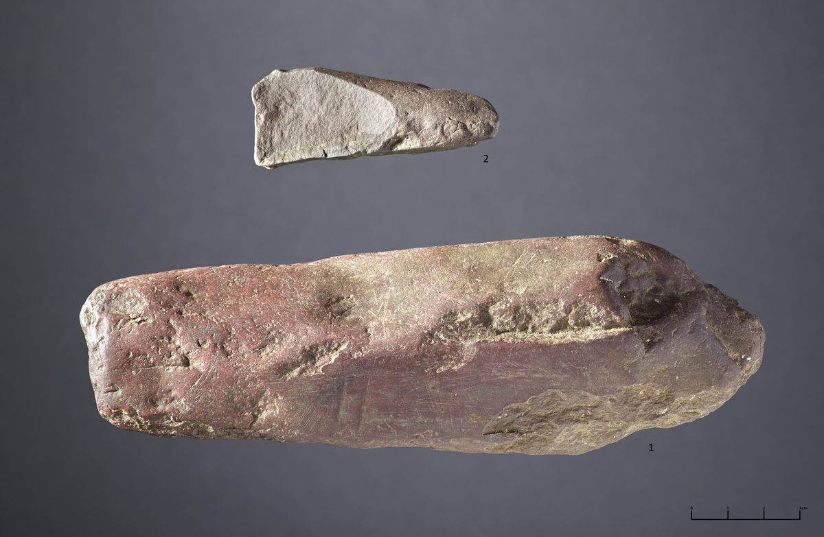 1 stk fragment av skifer, muligens emne til meisel. 6,85 cm på det lengste, 2,78 cm på det bredeste og 1,46 cm på det tykkeste.