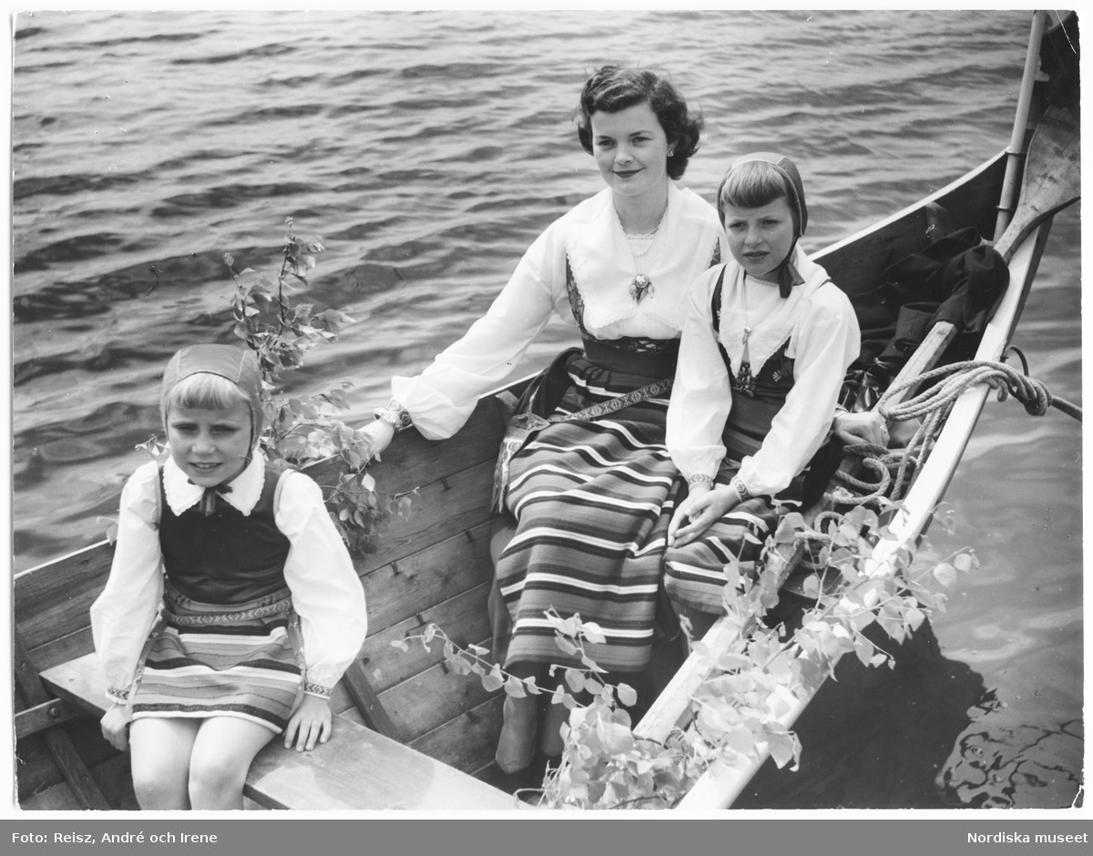 Dalarna. Kvinna med två flickor klädda i Rättviksdräkter i kyrkbåt på Siljan.