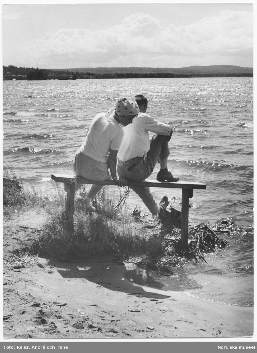 Dalarna. Afton i Rättvik vid Siljan. Ett par sitter på en bänk alldeles vid vattnet.
