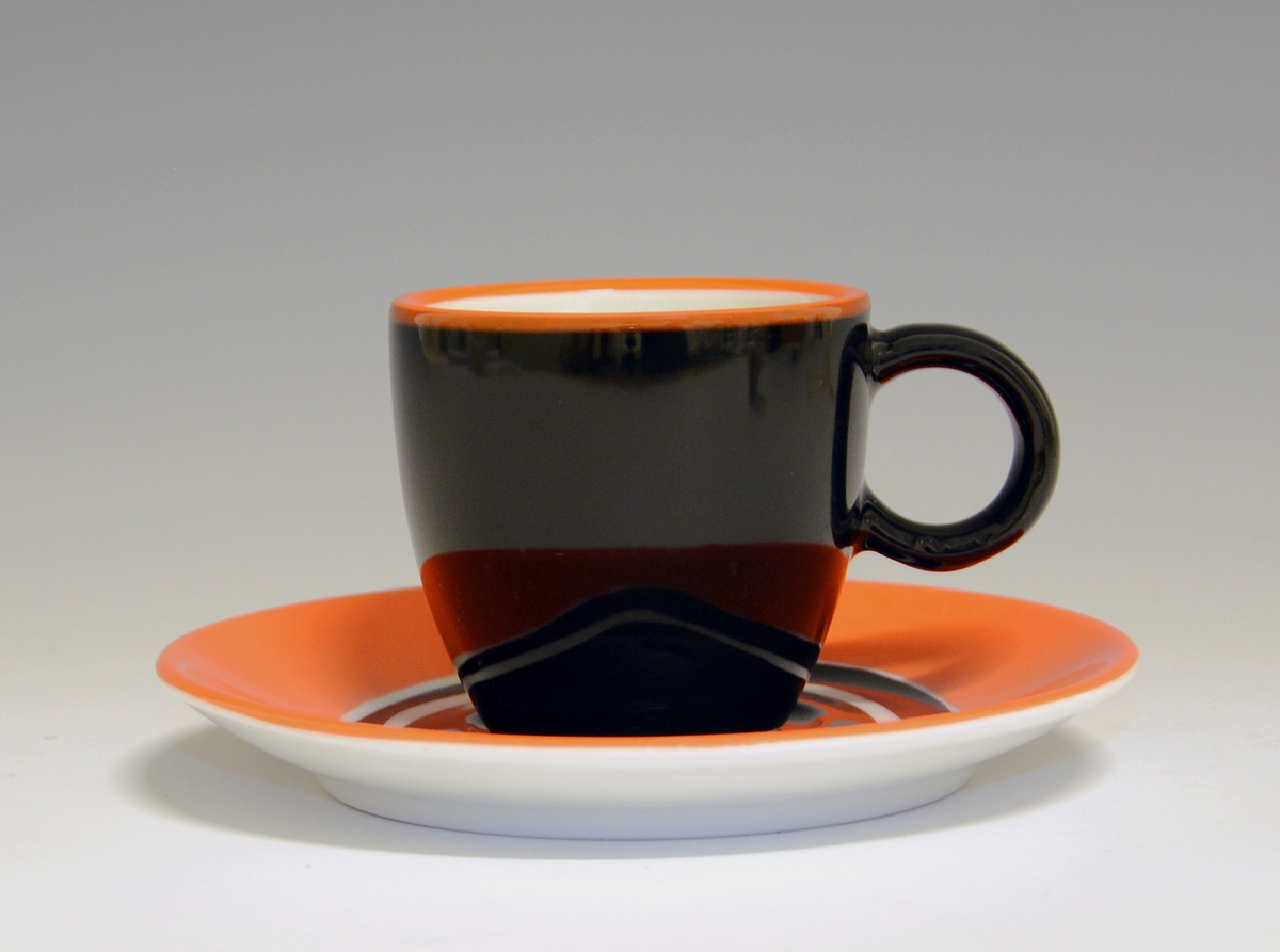 Espressokopp av porselen, med med rund hank. Sort med rød topprand, hvit inni.

Modell: Barista, forgitt av Poul Jensen.
Dekor: Gama

