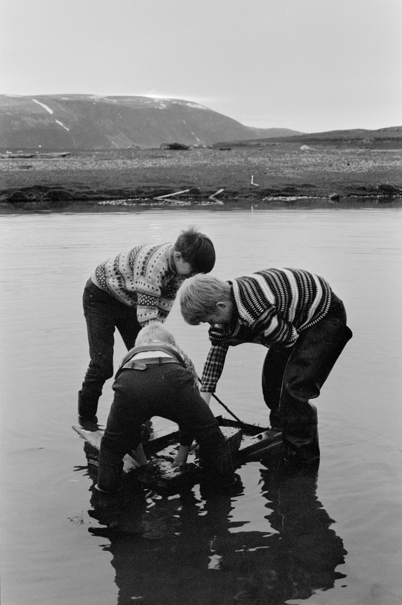 Tre gutter engasjert i ukjent aktivitet til knes i vannet.