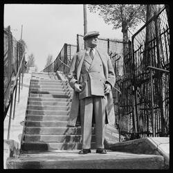 Maurice Chevalier i tweeddress og frakk fotografert i en tra