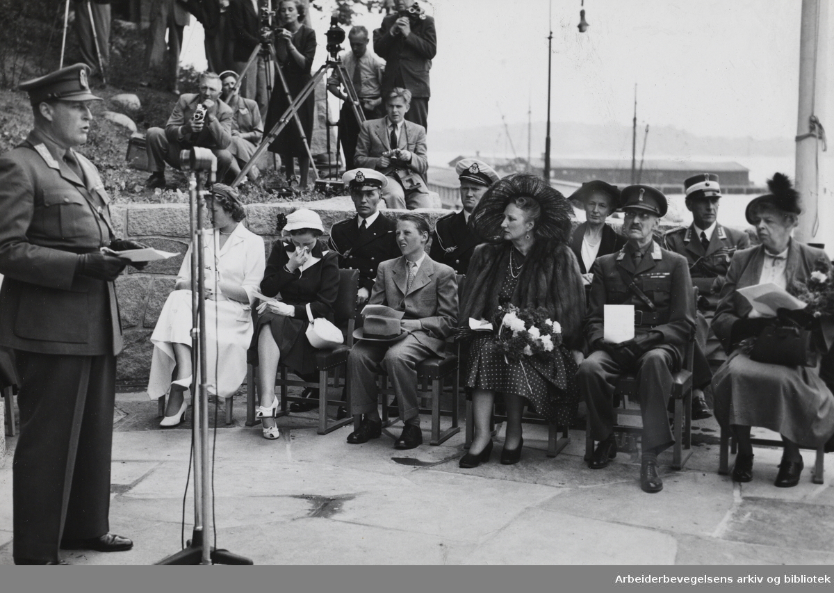 Kronprins Olav taler under avdukingen av Roosevelt-monumentet, 7. juni 1950. Sittende fra venstre: prinsessene Astrid og Ragnhild, prins Harald, kronprinsesse Märtha, kong Haakon VII og Eleanor Roosevelt. I annen rekke til høyre: oberst Nicolay Ramm Østgaard.