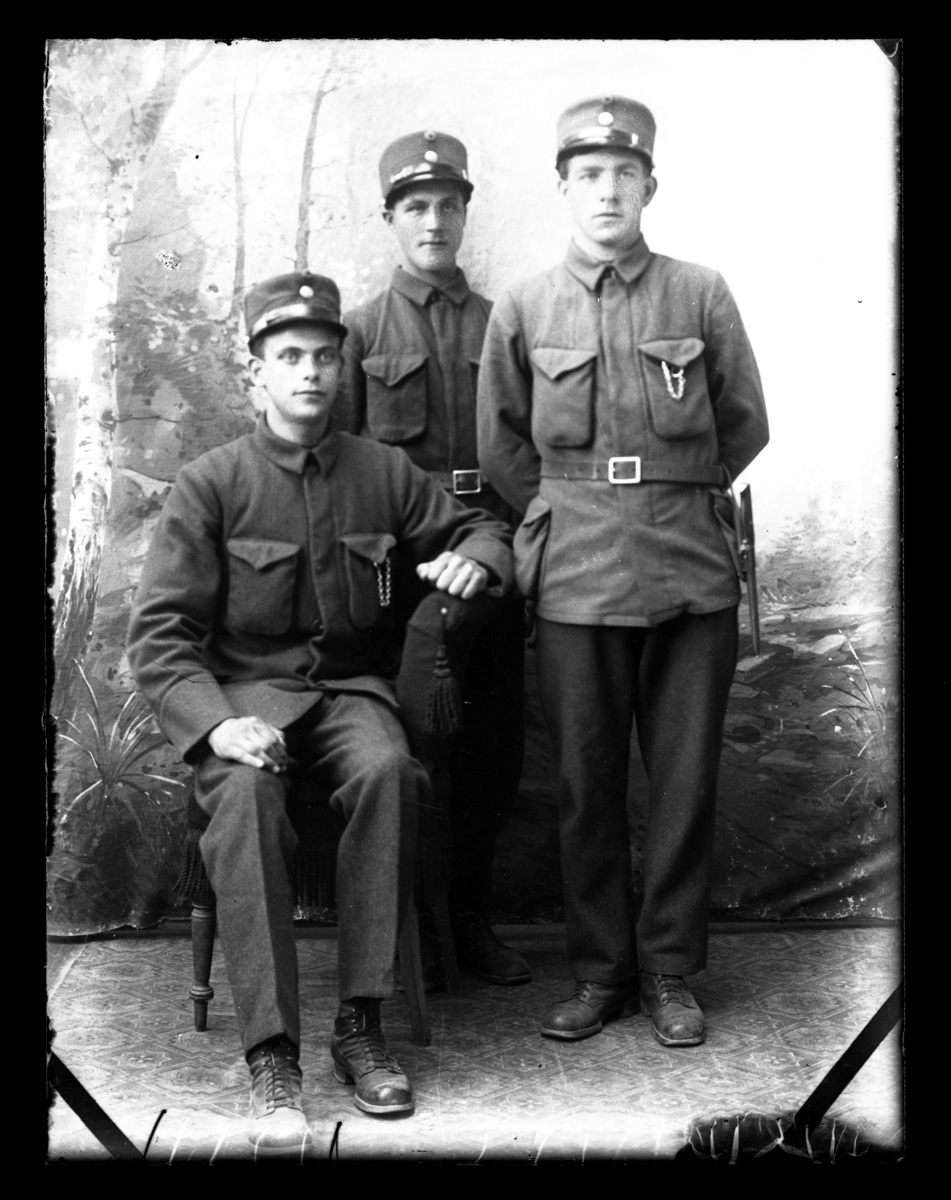 Atelierfoto.Tre soldater, en sitter og de to andre står.