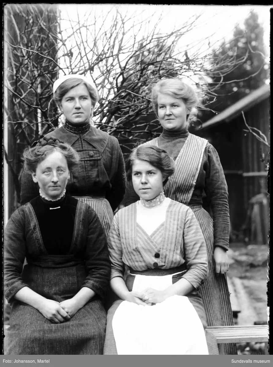 Porträttbild med fotografens systrar Märta Johansson, Sigrid Persson, Johanna "Hanna" Johansson samt, sittande till vänster, en oidentifierad kvinna.