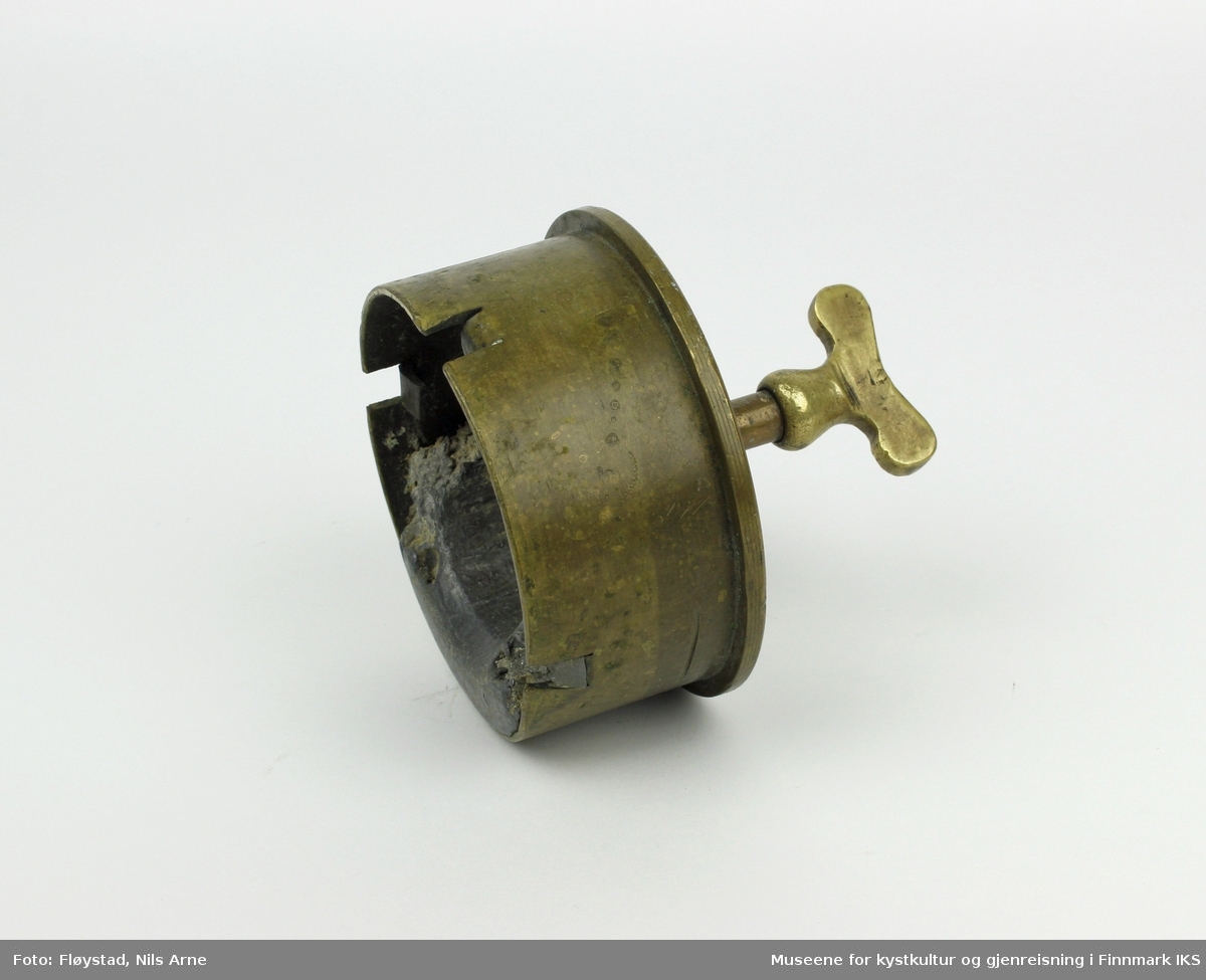 Et kokelodd laget av en 105 millimeter granathylse med en krannøkkel som håndtak. Det er støpt bly på innsiden av hylsen.  

Granathylsen har gravert den franske betegnelsen "105 L Mle 1913" og "ATE 9 L 49 X",  og var ammunisjonstypen til den franske feltkanonen "Canon de 105 L Mle 1913 Schneider" fra 1913. På innsiden av hylsen er det støpt bly.  

Håndtaket er en krannøkkel med spindel og nøkkelformet kranhode.