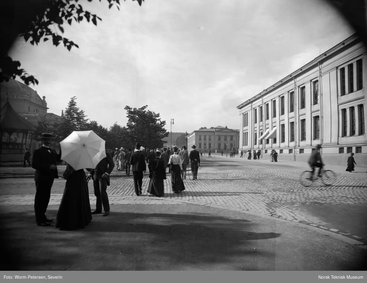 Spaserende på Karl Johan, fotografert fra Studenterlunden mot slottet, Nationaltheateret til venstre, omkring 1900