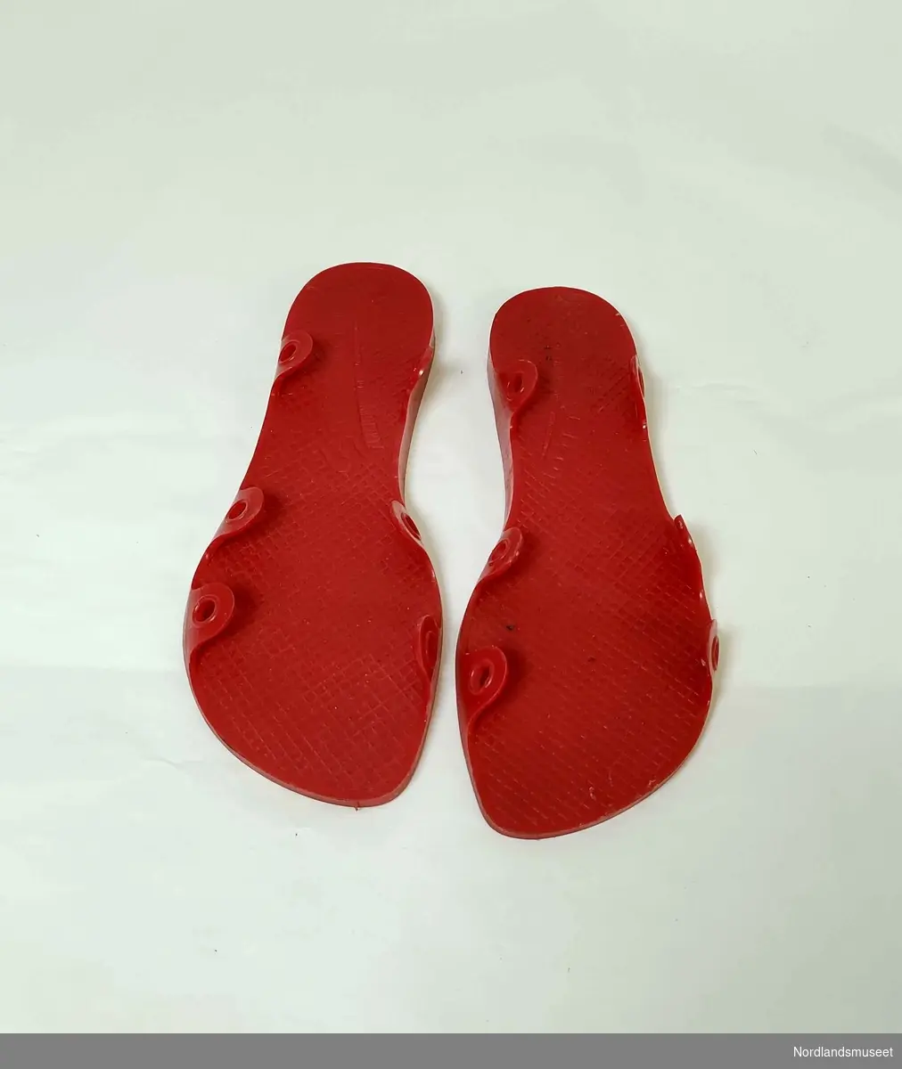 Røde sandaler til kvinne bestående av gummisåle og brede lisser som festes til denne. Str. 39.