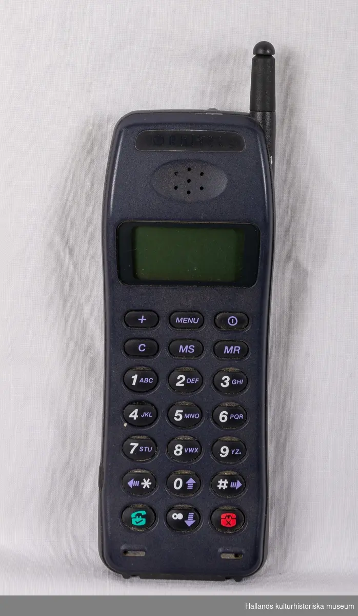 Orbitel 902 (Tillverkare: Orbitel, modell: 902) med yttre skal av svart och marinblå hårdplast. På framsidan finns en digital skärm, en gummerad knappsats, högtalare, mikrofon, samt tillverkarens logotyp: "Orbitel". Telefonen har en utfällbar pinnformad antenn. På baksidan av telefonen sitter ett batteri som löper utmed drygt halva telefonens längd. Även märkning: "Orbitel", "GSM". På telefonens undersida en kontakt under lucka.