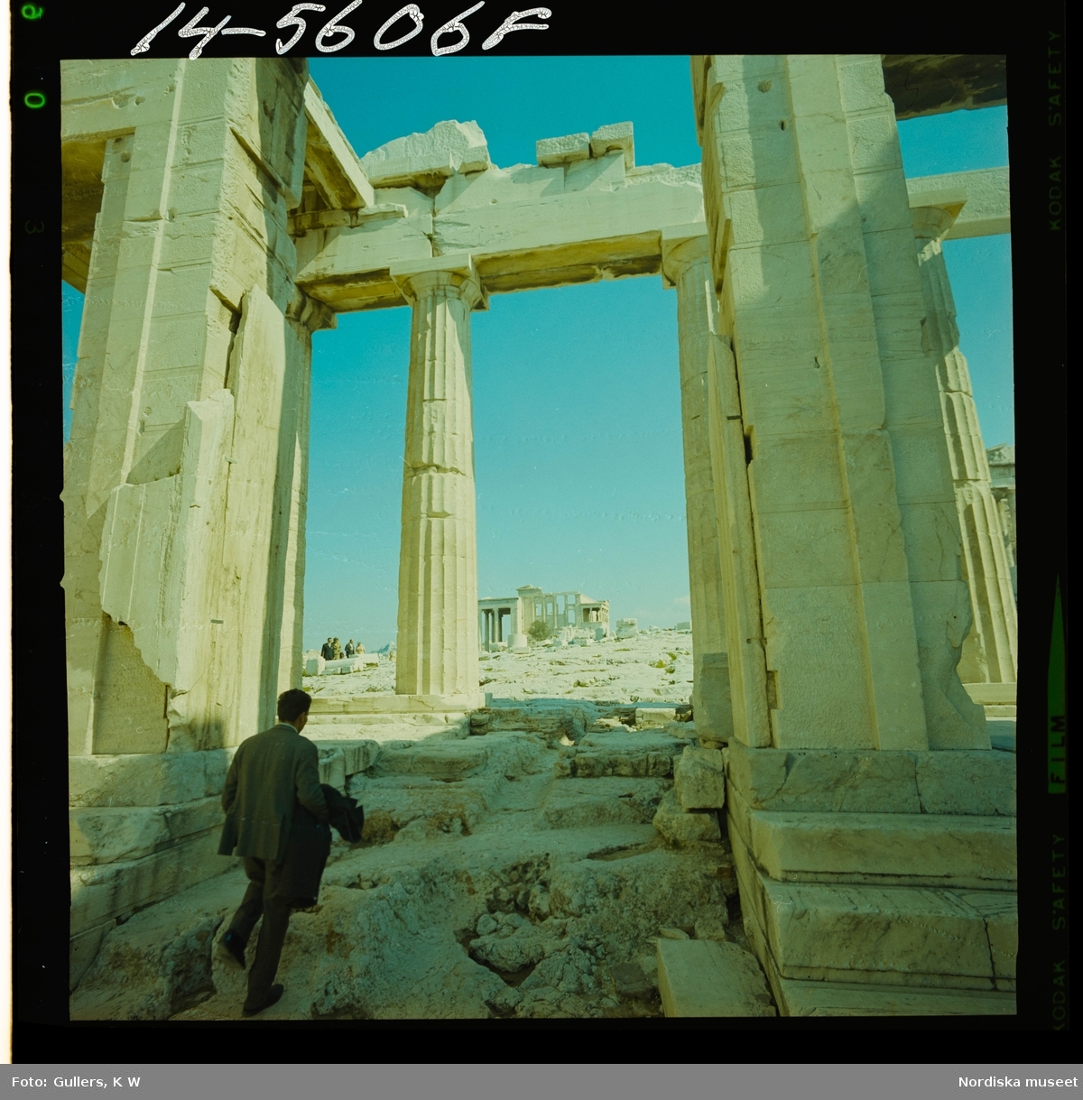 2795 Grekland Akropolis med runierna av bl.a. templen Parthenon och Erechtheion. En man påväg mellan kolonner.