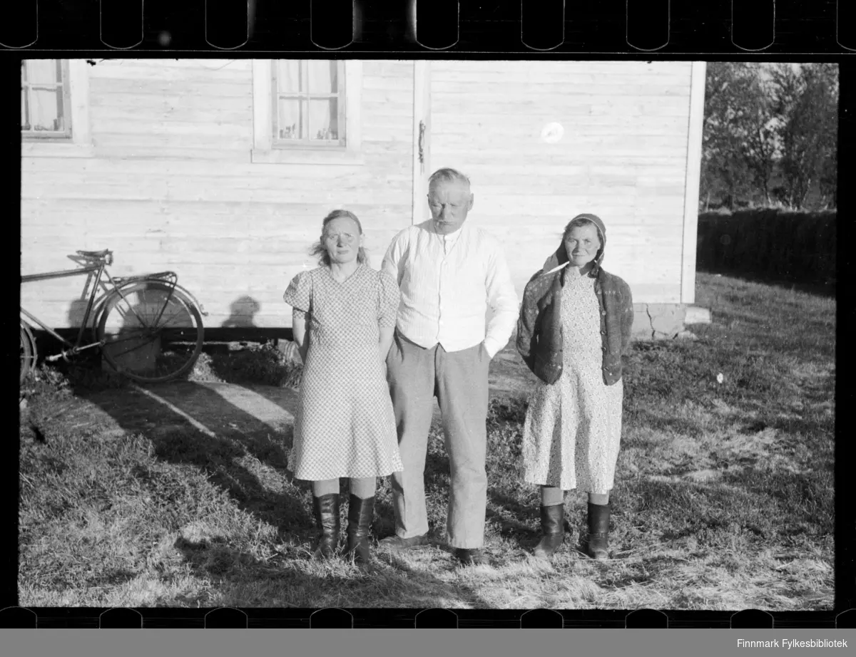 Foto av familie utenfor hus. Muligens familien Saba, usikker identifisering. 

Kvinnen til høyre har på seg et samisk hodeplagg 

Foto antagelig tatt på slutten av 1940-tallet, tidlig 1950-tallet 

Fotografiene  fbib.93112-191--198 er alle tatt på samme sted 