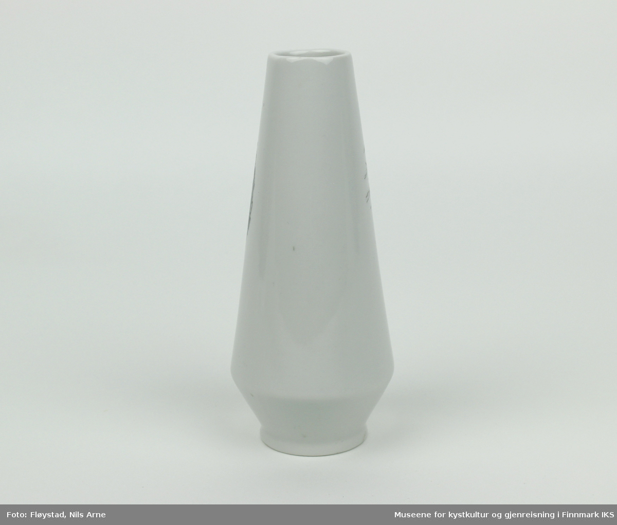 En balusterformet keramikkvase med en liten sirkulær munning og trykt dekor. Vasen er antakeligvis laget av bløtt porselen med hvit glasur. 
 
Dekoren er et sirkelformet trykt motiv av Nordkapplatået, med havet, sola og en lettskyet himmel i bakgrunnen. Nederst i motivet er det trykt "NORDKAPP" og de geografiske koordinatene "17°21''10", som antakeligvis kommer av en produksjonsfeil. De korrekte koordinatene er 71°10'21".