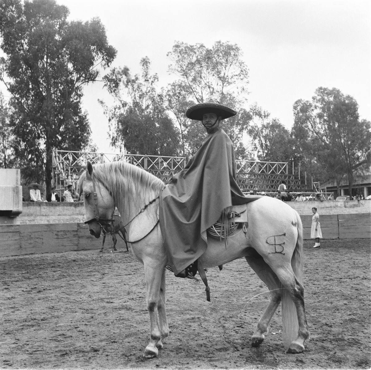 Mann med sombrero og poncho til hest.