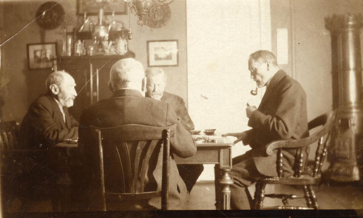 Fire menn spiller kort.