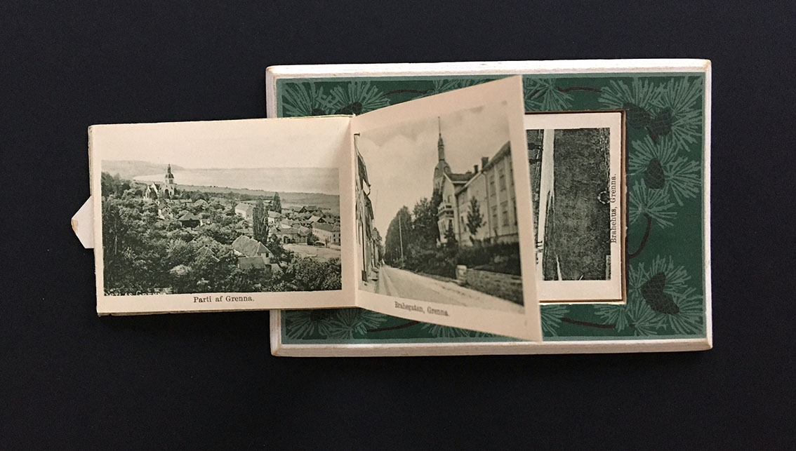 Ett något tjockare vykort med en liten lucka på framsidan där man viker ut en remsa med tolv små fotografier; motiv från Gränna och Visingsö kring sekelskiftet 1900 - sannolikt Callas Sundbecks fotografier.