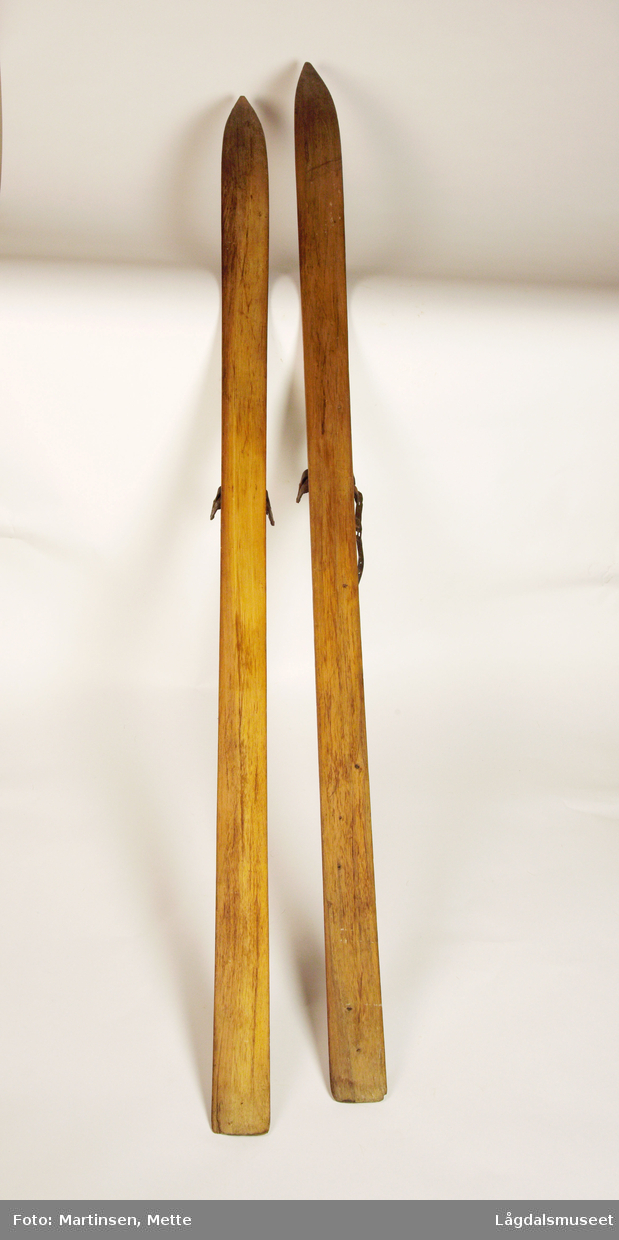 Et par treski. Midt på, på hver side, jernbelegg til binding. Den ene skien (merket Lm 961a) en liten del av lærreim til binding.