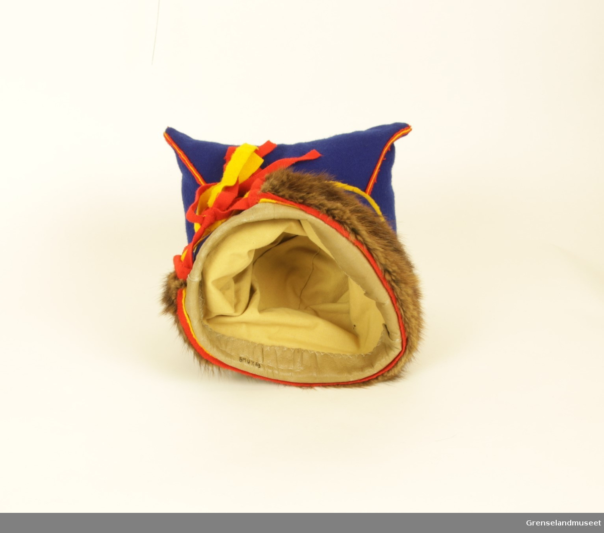 Gjenstanden er samisk firkantlue (herrer) av blått ull og med brun pelskant. På luens innside er kanten som går rundt hodet lagd av skinn. Luens sømmer er av rød og gul ull, og bandene bak i nakken er rød øverst, gul i midten, og rød nederst. Luens firkantete fasong kommer av at hver ende av firkanten er stappet med stoff.       
