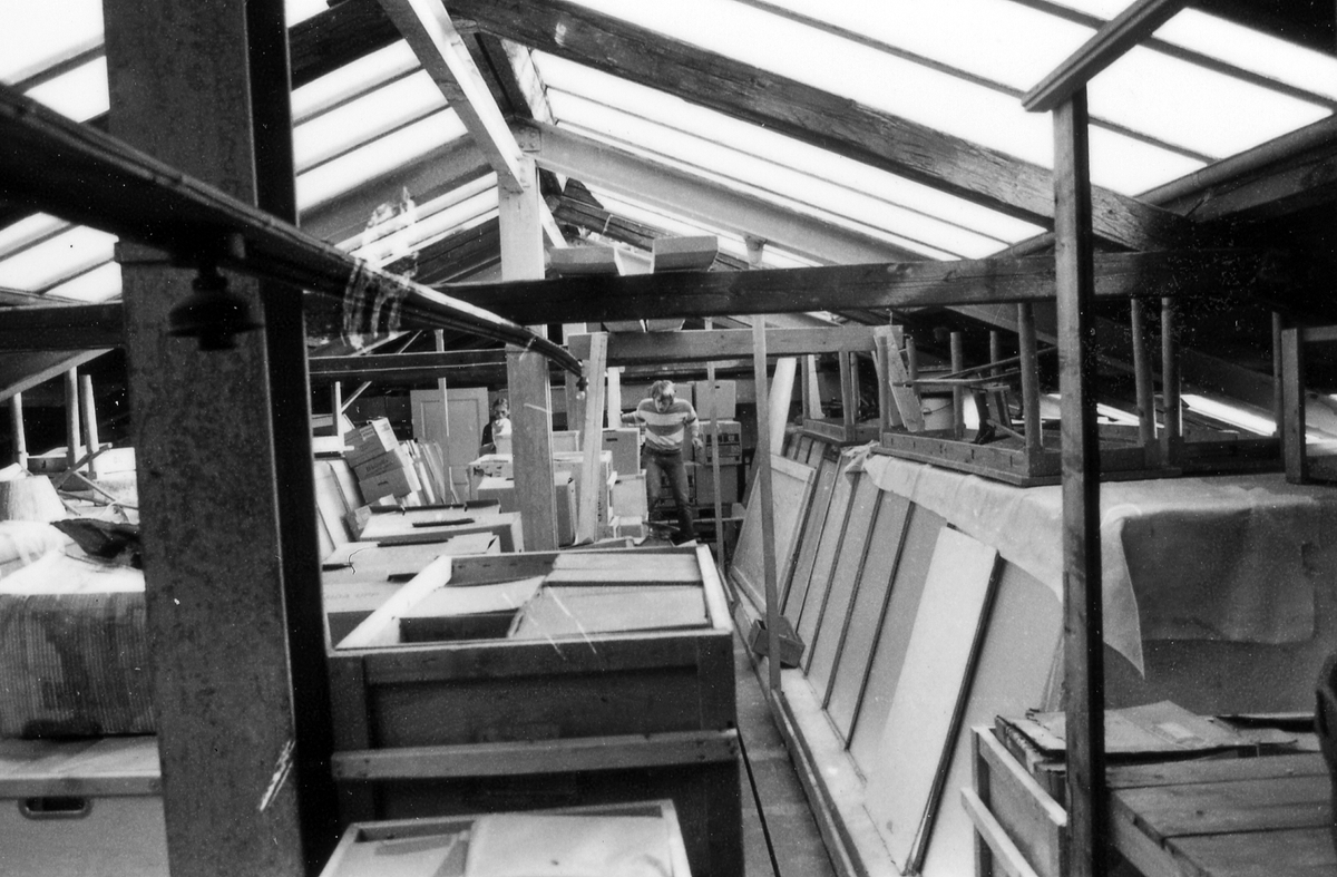 Museivinden, föremålen är nedpackade i lådor, ställda på pallar, lyfts med kran genom öppning i taket. 
Från reparationsarbetena den 1 september 1983.
