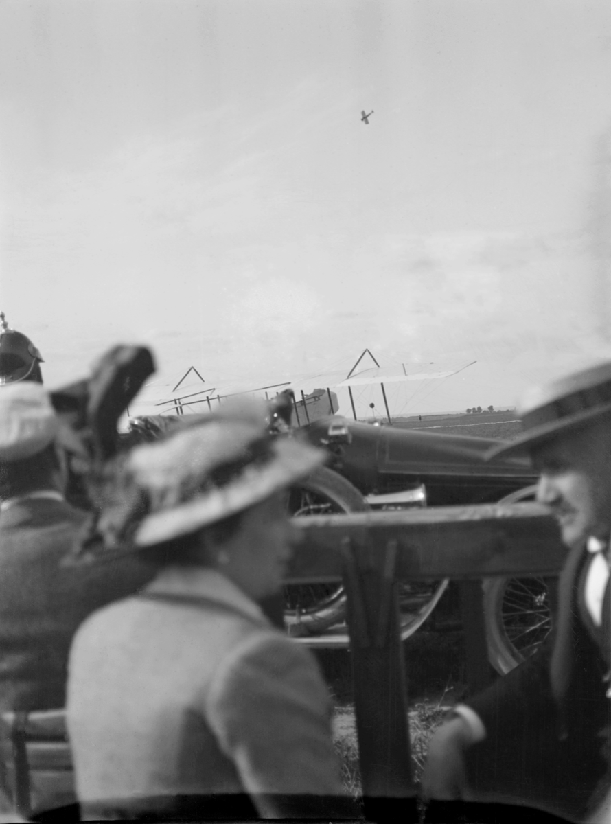 Flygplan och människor vid flygdag i Österrike-Ungern, tidigt 1910-tal. I luften flyger ett monoplan.
