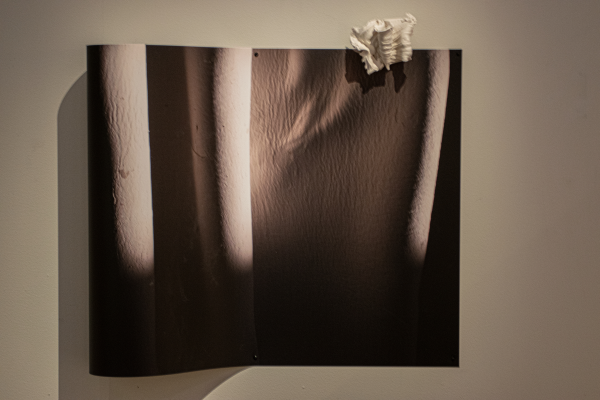 I foto och porslinslera visualiserar Marie Lindgren materialen; hur upplever vi leran i ett foto jämfört med den tredimensionella leran intill. Fotots mjuka vågform och dess skuggverkan mot väggen ger ytterligare effekt till verket.