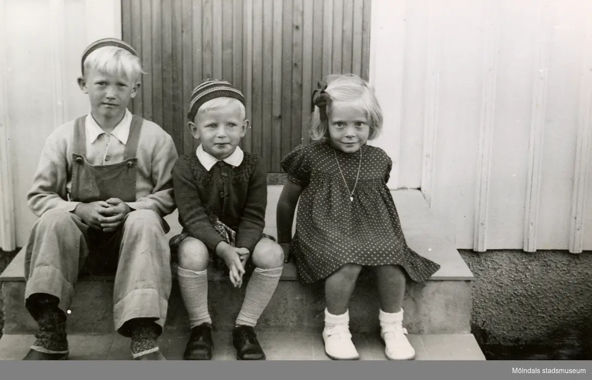 Tre kompisar står framför entrén till en villa i Torrekulla år 1948. Från vänster: Göran Andersson (som fyller år), brodern Christer Andersson och Eva Pettersson (född 1944, gift Kempe). Barnen var grannar med varandra.