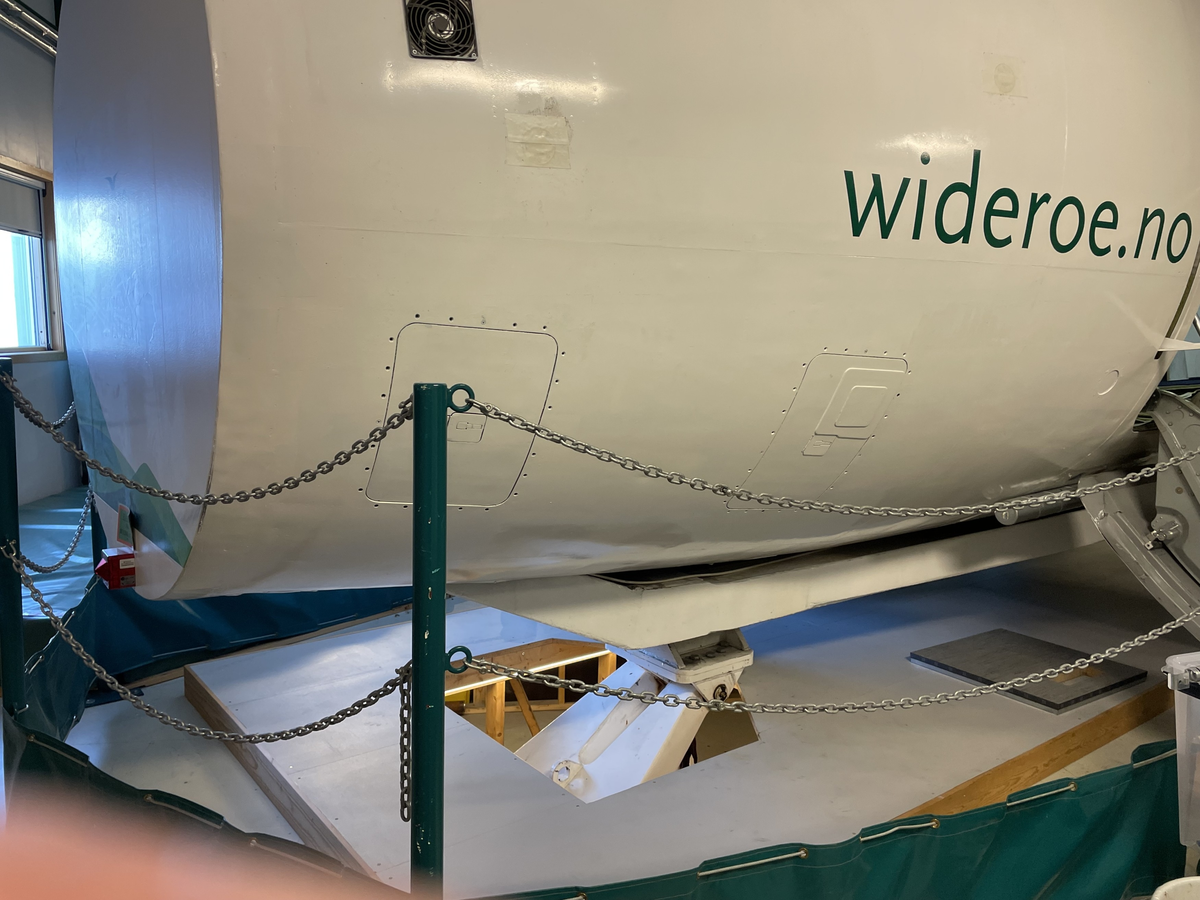 Widerøes Dash 8 kabinsimulator. Under flykroppen ses en del av det hydrauliske systemet som bidrar til å simulere flyets bevegelser.