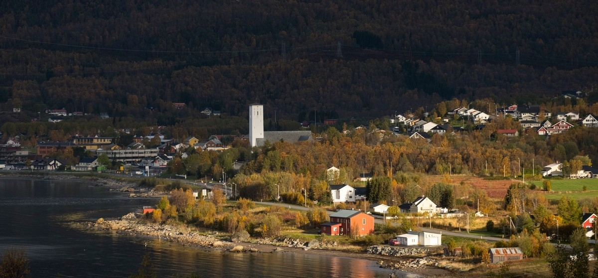 Bjerkvik i Narvik kommune. Bjerkvik og Bjerkvik kirke. Foto fra fjellanlegg på Medby. Solgløtt som vandret over bygda. Foto: Harald Harnang.