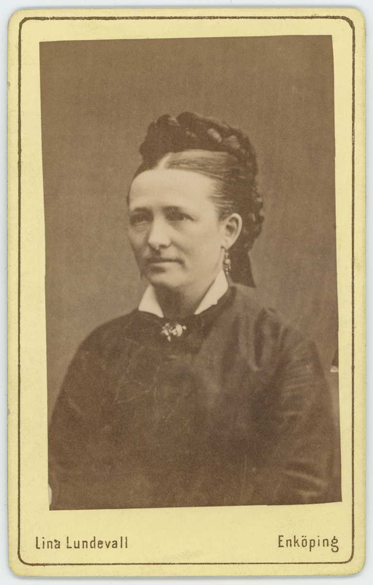 Svartvit porträtt av Carolina Lundberg ( står på baksida).