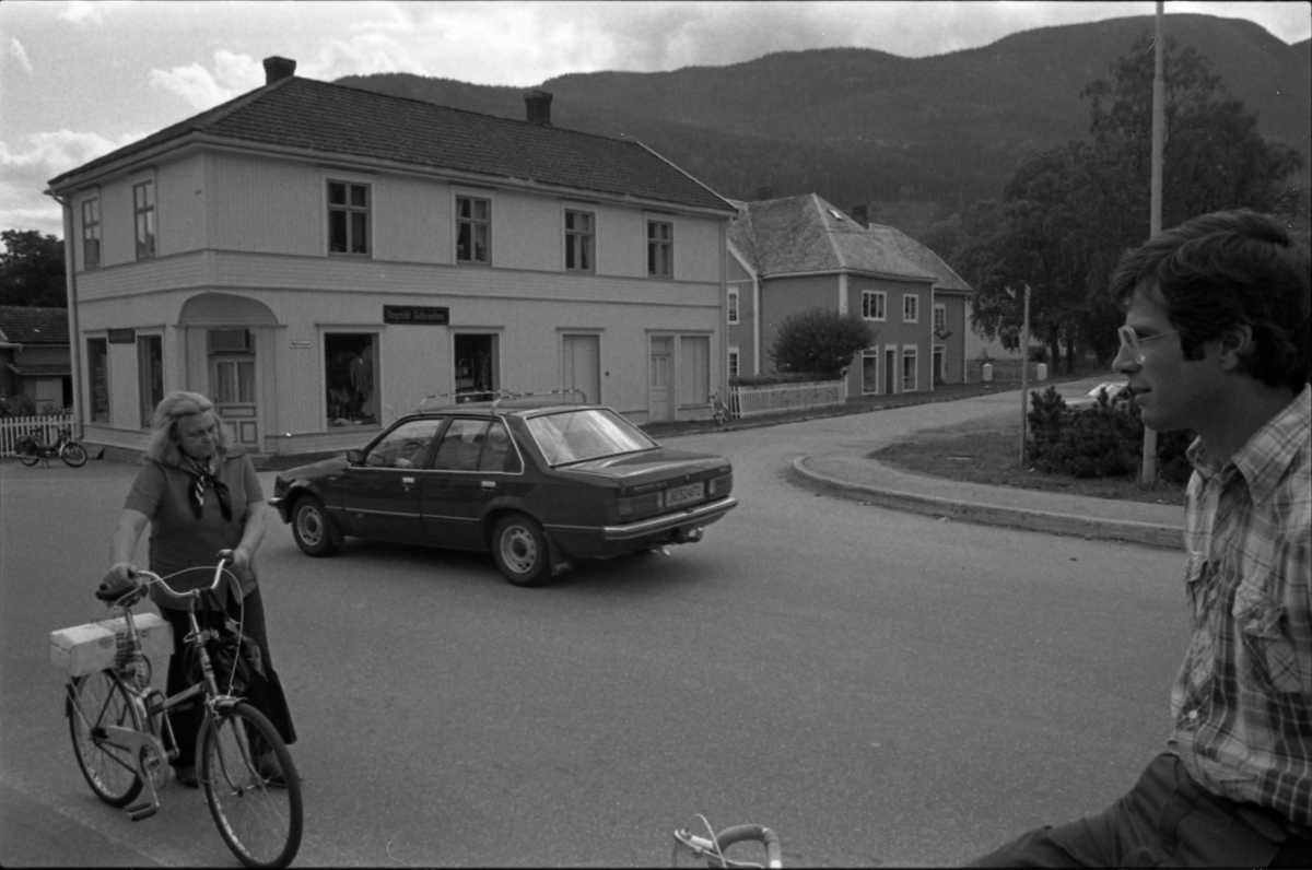 Nesbyen sentrum, i bakgrunn Bergården og Bjerringgården
Damen med sykkel er  Ruth Husemoen, gutten i forgrunn er Hans Tandberg
