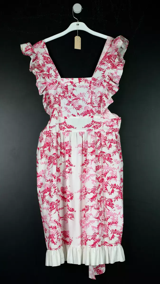 Klänning i förklädesmodell, sydd i textil med mönstret Gökärt i rosa nyanser.