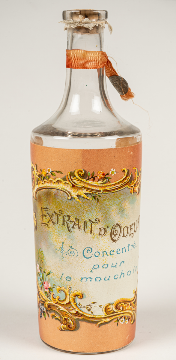 Parfymflaska i glas. etikett på flaskan; "Extrait o'deur" Concentr'e pour le mouchoir".
Parfymkoncentrat för näsduken.