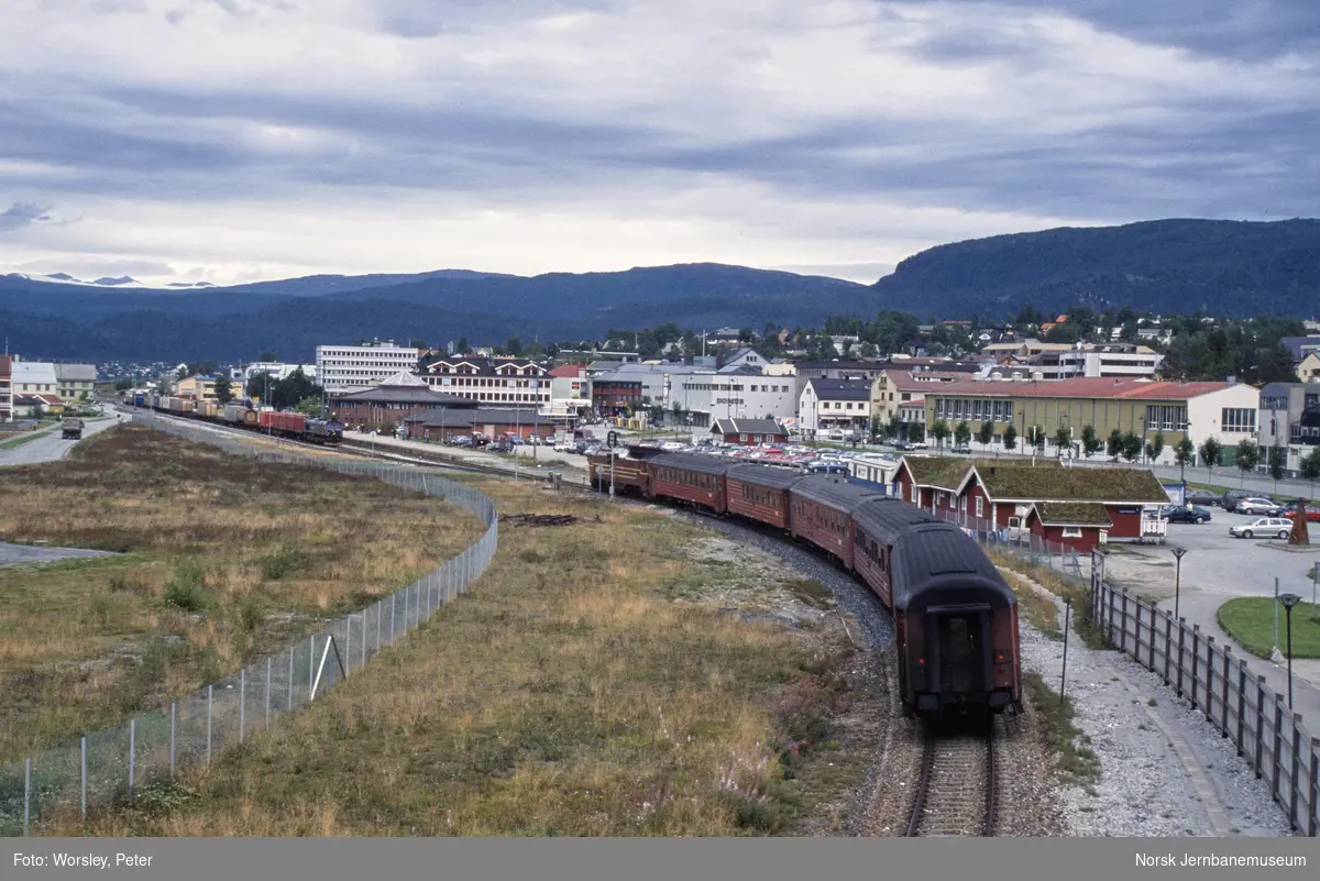 Diesellokomotiv Di 4 med persontog fra Trondheim til Bodø kjører inn til Mo i Rana stasjon, der kryssende godstog trukket av diesellokomotiv CD 66 404 venter i spor 2