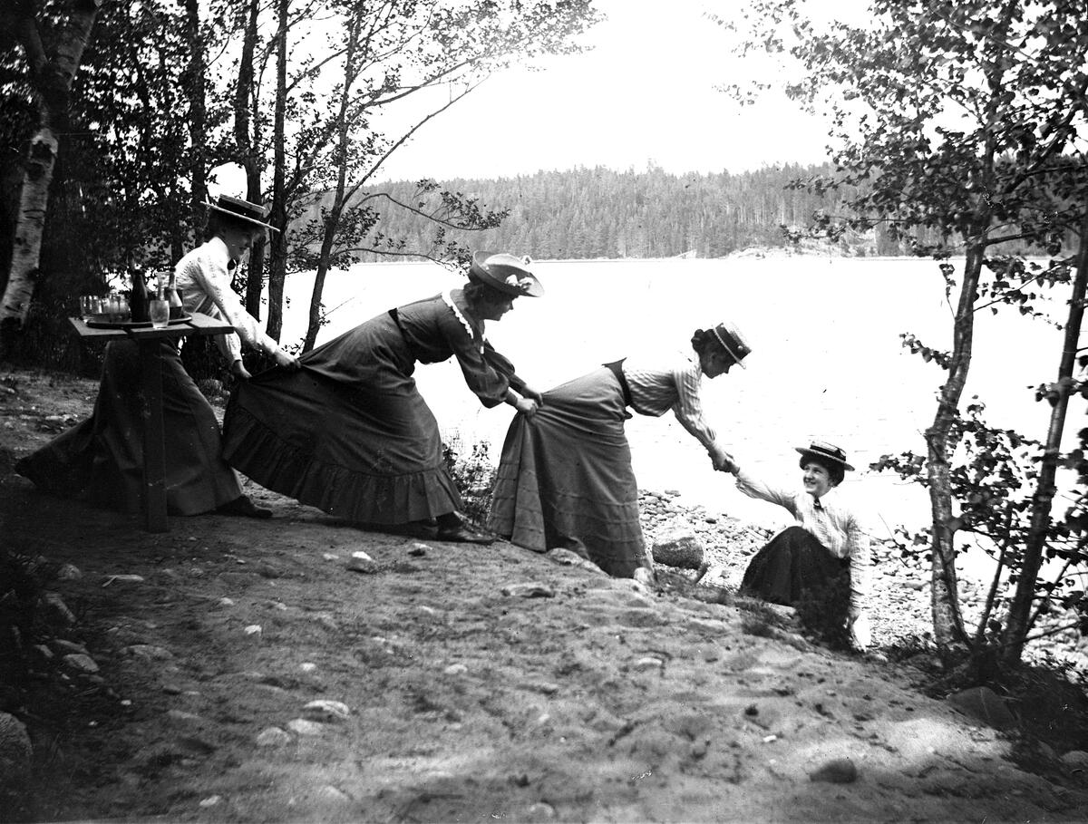 Flickor i långa kjolar vid Edsviken, nära Mörby. Fotot kan vara taget av Axel Pehrson som bodde i Sjöstugan vid Sätra äng. Troligen taget runt 1900.
