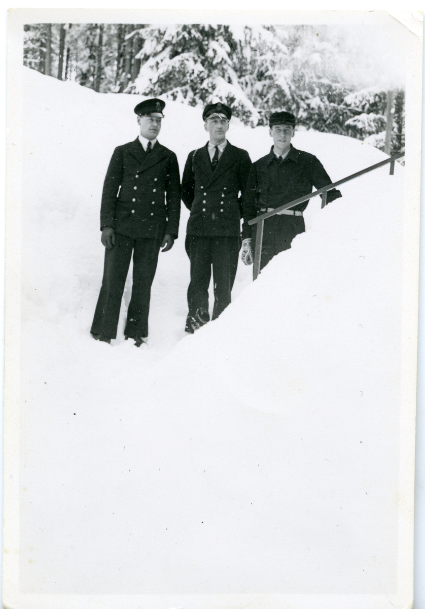 Tre män i tulluniform står vid räcke, Harald Sundling i mitten.