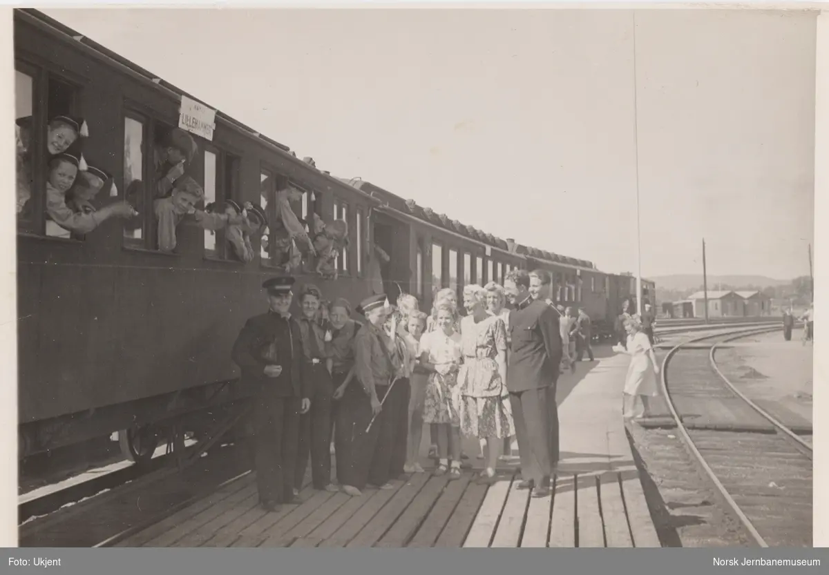 Persontog skiltet Hamar-Lillehammer på Hamar stasjon. På plattformen en gruppe reisende og to offiserer fra Frelsesarmeen